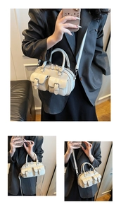Détail du sac Boston en cuir ciré crème avec deux poches avant à boucle et bandoulière