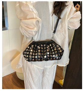 Sac dumpling noir froncé avec rivets argentés porté par un mannequin en studio