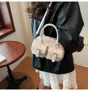 Détail du sac Boston blanc crème avec poches utilitaires et bandoulière réglable