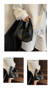 Close-up of minimalist black leather cloud bag with soft texture and sleek integrated handle