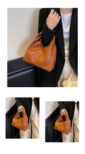 Detail of a brown pleated PU leather crescent bag for casual minimalist commuting style