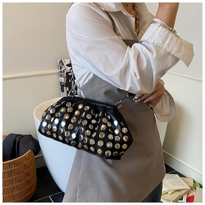 Détail d'un sac nuage en cuir noir avec rivets argentés et bandoulière en chaîne