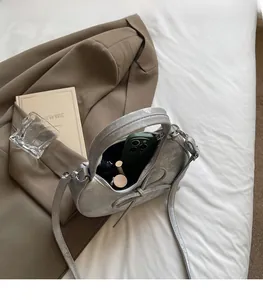Vue intérieure du sac demi-lune argenté montrant l'espace pour téléphone et maquillage