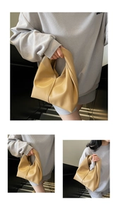 Detailed macro view of soft khaki leather texture and vertical stitching on slouchy cloud bag