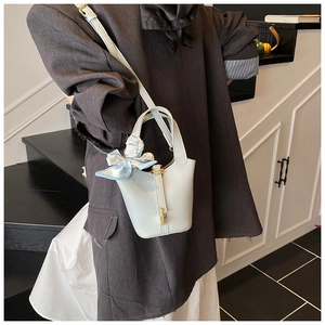 Hellblaue Leder Eimer Tasche Detailansicht mit schickem Schal-Akzent und goldener Schließe.