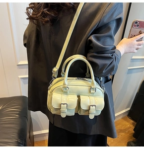 Détail du sac Boston vert clair avec deux poches avant et des boucles argentées