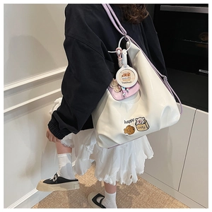Vue détaillée du sac cabas blanc brillant avec lanières violettes et broderies