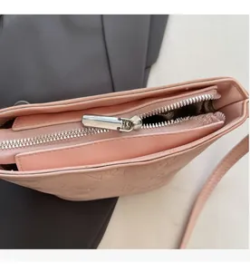 Détail de la fermeture éclair en métal argenté et texture gaufrée rose du sac