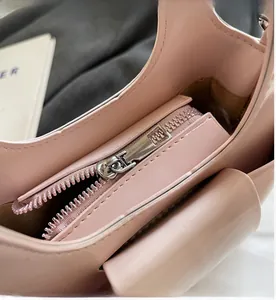Gros plan sur la fermeture éclair en métal argenté du sac à main en cuir verni rose