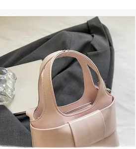 Détails de la poignée large et de la sangle sur un sac seau rose avec fermeture éclair