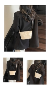 Gros plan d'un sac seau crème avec motifs de papillons embossés et détail du logo SNML