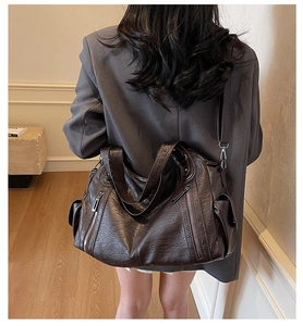 Detail view of large dark brown tote bag in vintage oiled leather with zip pockets
