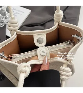 Detail of lychee pattern leather bag showing magnetic closure and interior zip pocket