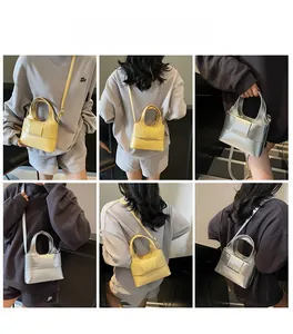 Détail du nœud tissé sur un sac à main minimaliste en similicuir jaune et argenté
