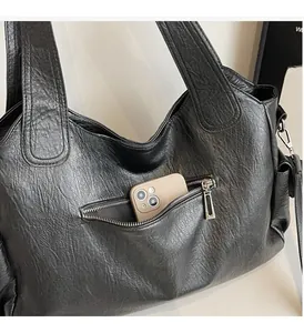 Detail of black tote bag featuring a practical front zipper pocket for smartphone storage