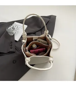 Interior view of cream bucket bag showing spacious storage for phone and wallet