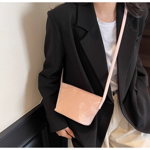 Mini sac seau rose avec gaufrage SNML porté sur une tenue de blazer noir