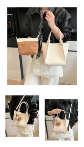 Détails du sac seau en cuir blanc cassé avec poignée nouée et breloque ours