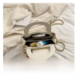 Detail showing the internal storage capacity and compartments of the cream quilted bag