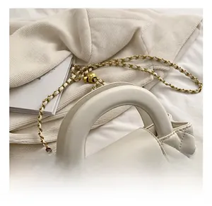 Close-up of the white quilted leather pattern and gold rectangular twist lock on the bag