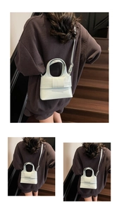 Détail du sac seau vert menthe avec nœud décoratif et fine bandoulière en cuir souple