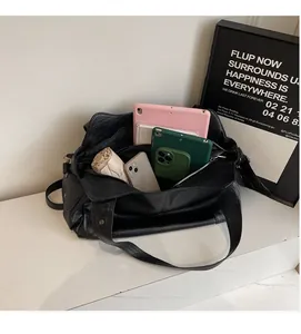 Detail shot showing internal capacity of large black tote bag with tablet and daily items