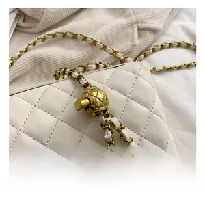 Detailed macro view of white quilted leather texture and golden metal chain strap