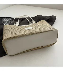 Detailed view of steady white leather base and fine straw weaving of this tote bag