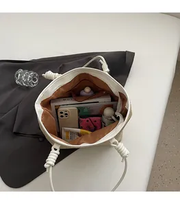 Interior detail of large woven tote bag showing brown lining and zipper pocket capacity