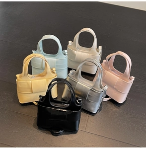 Vue à plat de sacs à main à nœud papillon en six couleurs sur bois sombre
