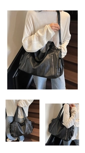 Macro shot of large black faux leather tote bag with functional exterior zippers