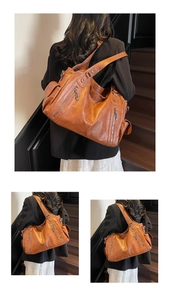 Detailed view of brown leather tote bag with functional zippers and side pockets