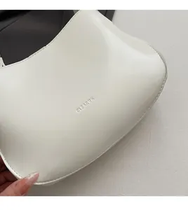 Close-up of CLEAR'K white leather bucket bag showing soft texture and flexible material