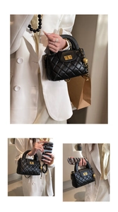 Detail of black quilted handbag featuring gold twist lock and metal chain strap