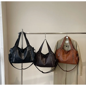 Detailed view of tote bags in black, dark coffee and caramel with dual zipper pockets