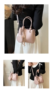 Detailed view of pink pebble leather bucket bag with knot handles and round coin purse