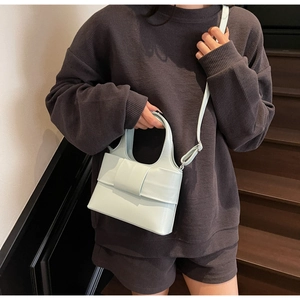 Détail du sac à main vert menthe avec grand nœud sur le rabat et texture cuir lisse