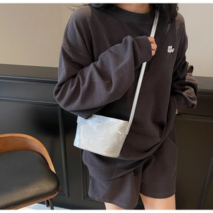 Détail d'un sac seau argenté avec logo SMMI embossé et finition à texture gaufrée