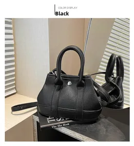 Macro detail of black litchi texture leather handbag with silver metallic twist lock
