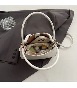 Internal view of white PU bucket bag showing large capacity with phone and cosmetics