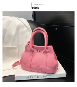 Close-up of pink lychee grain leather bucket bag with silver metal buckle and handle