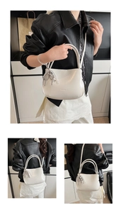 Detailed close-up of white PU leather bucket bag with silver tassel and sleek metal handles