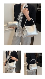 Detail of silver metallic bucket bag with chain bow and matching inner pouch on model