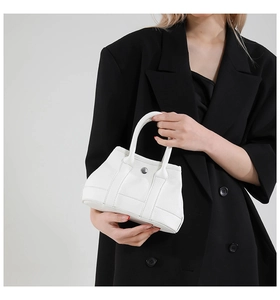 Detail view of mini white lychee pattern leather tote bag with round metal snap button