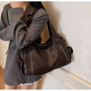 Detail shot of a dark brown large tote bag featuring functional multiple zipper pockets