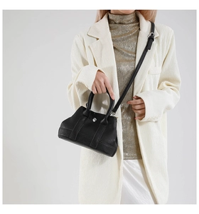 Close-up of black lychee grain leather tote with silver hardware and adjustable strap