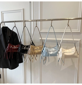 Fila de bolsos de hombro en charol de cinco colores con cremalleras de borla larga