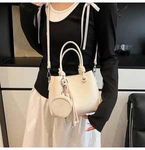 Detail of lychee textured leather bucket bag with knotted handles and coin purse