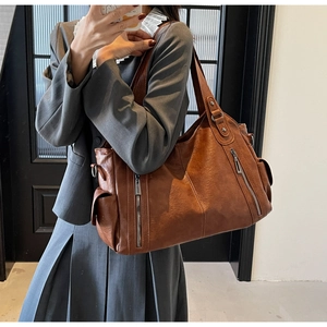 Détail du sac cabas vintage en cuir PU marron avec des fermetures éclair décoratives