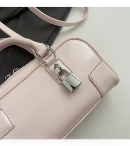 Detail of light pink leather handbag showing the silver padlock and smooth texture